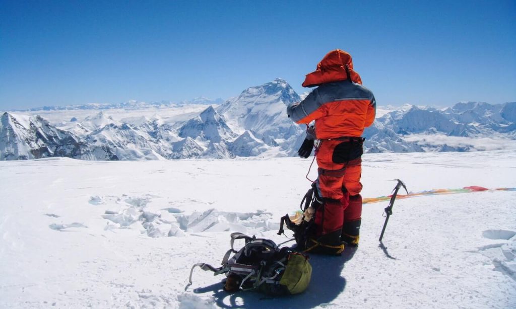 Ein Bild eines erfahrenen Wanderers, der sich selbstbewusst durch das verschneite Gelände bewegt und den Bedingungen entsprechend gekleidet und ausgerüstet ist.